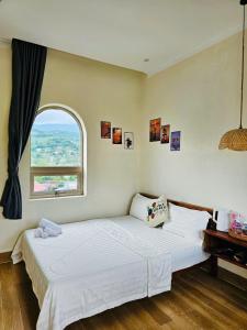 a bedroom with a large white bed with a window at Khách Sạn Trung Loan in Ninh Hải +37 photos