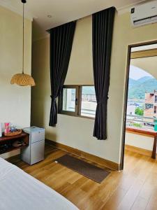 a bedroom with a bed and a window with a view at Khách Sạn Trung Loan in Ninh Hải