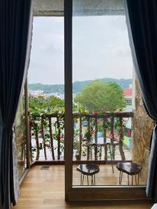 a room with a balcony with a view of a garden at Khách Sạn Trung Loan in Ninh Hải