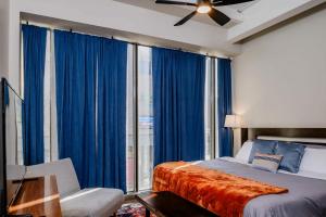 ein Schlafzimmer mit einem Bett und einem Fenster mit blauen Vorhängen in der Unterkunft Penthouse City Overlook 2BR Apartment - free parking in Appleton