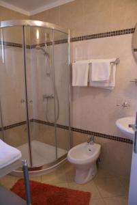 een badkamer met een douche, een toilet en een wastafel bij Apartment Adria Sun in Porat