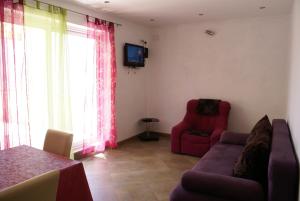 a living room with a couch and a chair and a television at Apartment Adria Sun in Porat