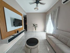 a living room with a couch and a tv at Villa Nurami in Malacca
