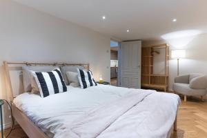 a bedroom with a large white bed and a chair at Fellin Apartment in Viljandi