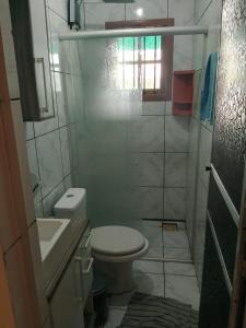 een kleine badkamer met toilet en wastafel bij Kitnet com garagem e Wi-Fi in Tramandaí