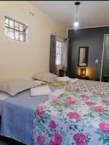 a bedroom with a large bed with a floral bedspread at Recanto Nova Vida in Ibiapina