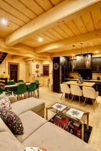 a living room with couches and a table and a kitchen at Villa Alexandra jacuzzi i sauna in Kościelisko
