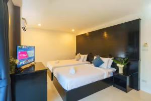 een hotelkamer met twee bedden en een flatscreen-tv bij AP Apartment in Kathu