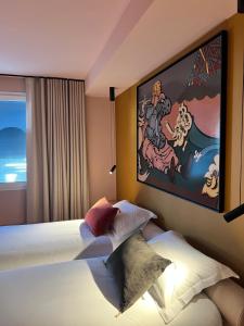 a hotel room with two beds and a painting on the wall at Yatt Hotel in Arcachon