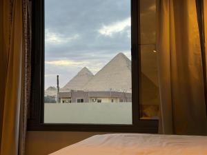 a view of the pyramids from a bedroom window at Zahira Pyramids View in Cairo