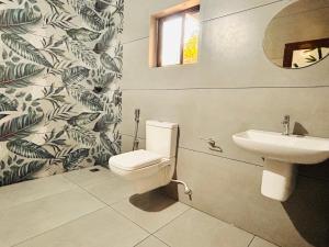 un baño con inodoro y lavabo en Marari Beach Cleetus Homestay, en Alleppey 53 fotos más