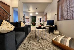 バンガロールにあるEden Green Nestのソファとテーブルのあるリビングルーム