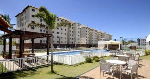 a resort with a pool and tables and chairs at VOG Torres do Sul Litoral Ilhéus in Ilhéus