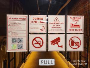 a bunch of signs that are on a wall at Mi Amor Luxury Hostel located in South Island Center in Phú Quốc