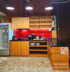 a kitchen with a black counter top and wooden cabinets at Mi Amor Luxury Hostel located in South Island Center in Phu Quoc