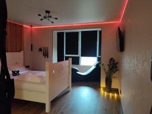 a bedroom with a white bed and a red light at Тематичні апартаменти in Zhytomyr