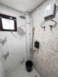 a bathroom with a shower with a glass door at Kugi Hostel - Self Check-in Capsule Hostel near Cebu Airport in Cogon