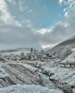 a town on a snowy hill with a river at Shgedi Mestia in Mestia