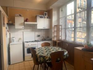 a kitchen with a table and a white stove top oven at Villa Ramuntcho in La Bourboule