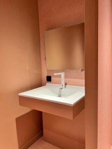 a bathroom with a sink and a mirror at Yatt Hotel in Arcachon
