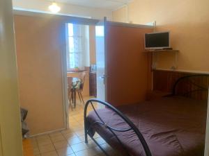 a bedroom with a bed and a tv on the wall at Villa Ramuntcho in La Bourboule