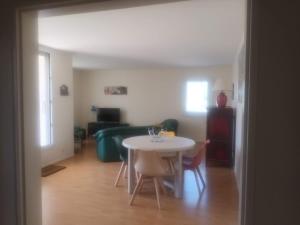 een woonkamer met een tafel en een bank bij Super Apt terrasse 2box in Olivet