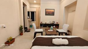 a bedroom with a bed and a table and chairs at Parinuj homestay in Chittaurgarh
