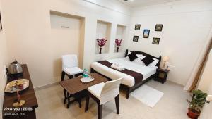 a bedroom with a bed and a table and a dining room at Parinuj homestay in Chittaurgarh +2 photos