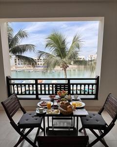 a table with food and a view of the ocean at Hawana Apartment in Salalah