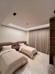 a bedroom with two beds and a window at Hawana Apartment in Salalah +7 photos