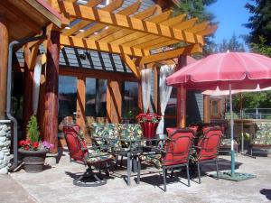 a patio with a table and chairs and an umbrella at Paradise Acres Ranch in Nanoose Bay