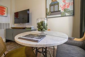 einen Tisch mit einer Vase Obst darüber in der Unterkunft The Magnolia Retreat in Historic Savannah 1BR in Savannah