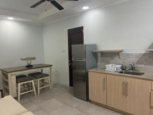 a kitchen with a stainless steel refrigerator and a table at Paradise Beach Hotel in Kingstown