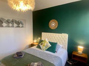 a bedroom with a bed and a green wall at Résidence Costa Vermella, vue mer et montagne au calme in Cerbère