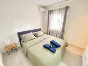 Un dormitorio con una cama grande con almohadas azules. en Tempus Central - Bazaar Metro Supermarket Resto, en Quatre Bornes 14 fotos más