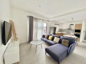 Una sala de estar con un sofá azul y una mesa. en Tempus Central - Bazaar Metro Supermarket Resto, en Quatre Bornes