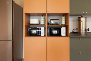 a kitchen with two toaster ovens on a shelf at WOW Hostel in Krakow