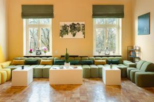 a living room with couches and tables and windows at WOW Hostel in Krakow