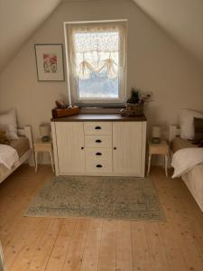 a bedroom with a window and a dresser with a television on it at Cudne Manowce ogrodzony domek na wyłączność wśród ciszy i natury u stóp Gór Izerskich in Giebułtów