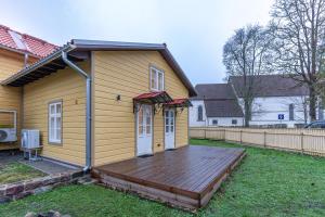 a house with a wooden deck in the yard at Fellin Apartment in Viljandi