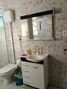 un bagno con un water, un lavandino e uno specchio di Pousada M&J a São Gabriel