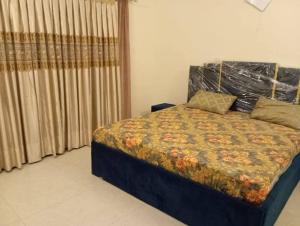 a bedroom with a bed with a floral comforter at Haider GuestHouse in Karachi