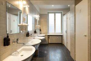 a bathroom with three sinks and two mirrors at WOW Hostel in Krakow +106 photos