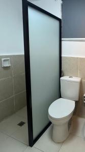 a bathroom with a toilet and a glass door at Casa Josa in Antipolo +18 photos