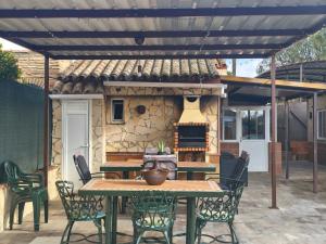 a patio with a table and chairs and a fireplace at RURAL EL SANTISCAL in Arcos de la Frontera