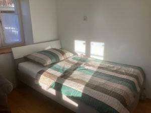 a bed with a plaid comforter in a bedroom at Ferienwohnung Weißenstein in Weissenstein