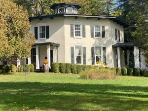 a large white house with a tower on top of it at Black Sheep Inn in Hammondsport