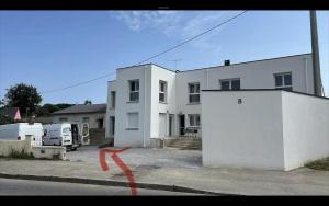 une maison blanche avec une ligne rouge dans la rue dans l'établissement Le Chalet Savoyard, à Hennebont