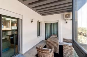 a balcony with wicker chairs and a table and windows at Large Comfort Duplex Casablanca Center in LʼOasis