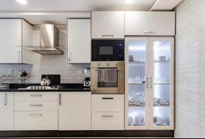 a kitchen with white cabinets and a microwave at Large Comfort Duplex Casablanca Center in LʼOasis